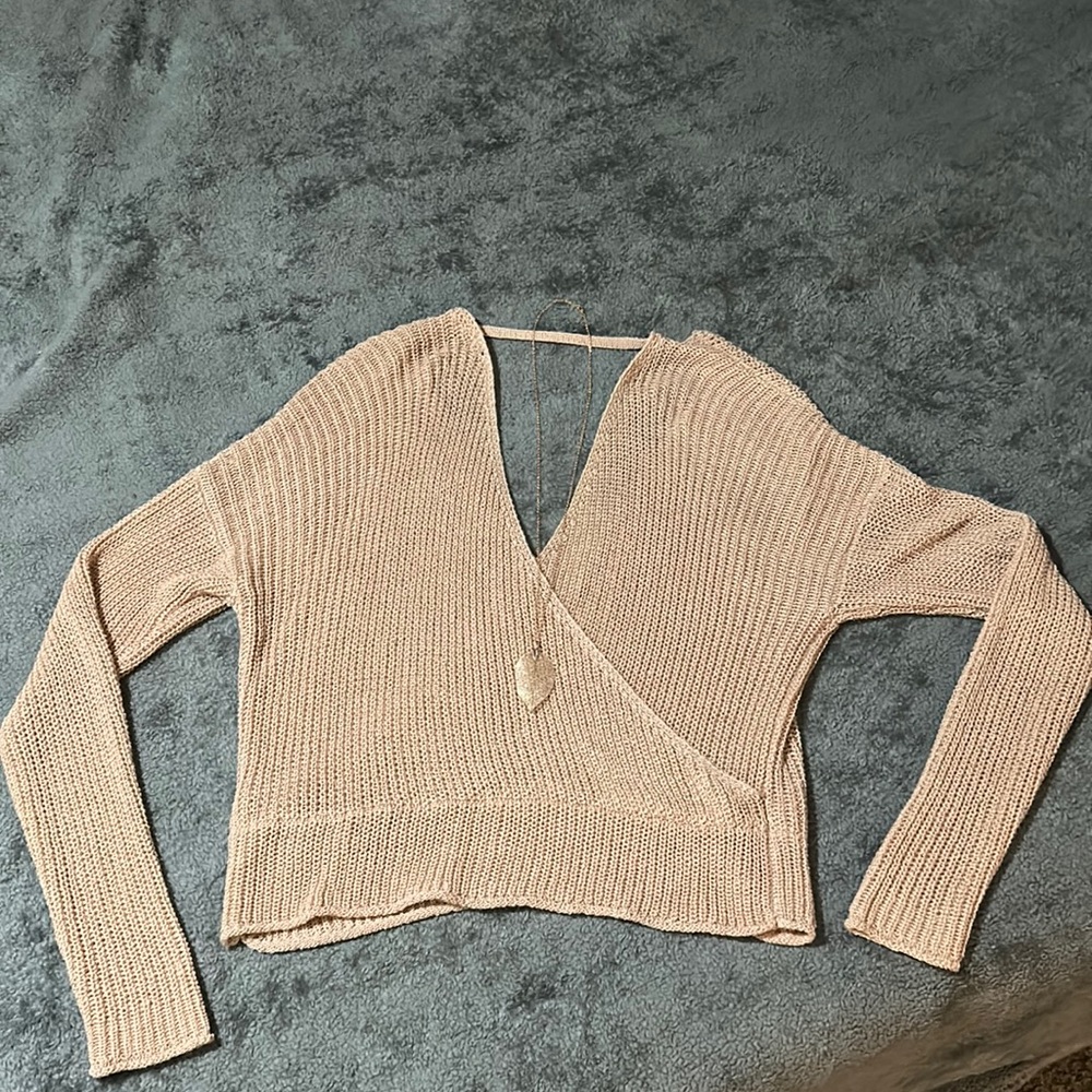 Dusty pink very low cut sweater. It has a V shape cut in the front and back.